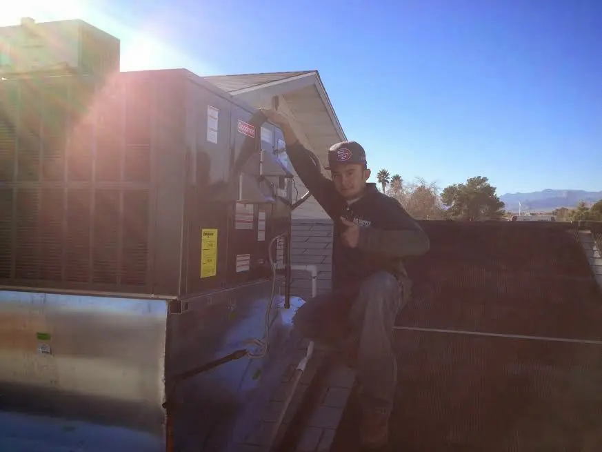 HVAC technician performing AC Tune-Up on a rooftop unit in Morgan City